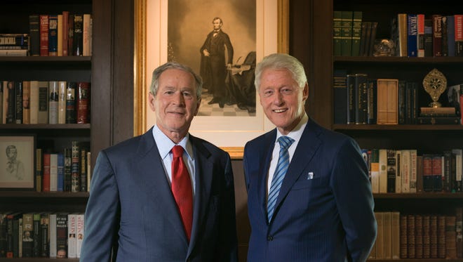 George W. Bush and Bill Clinton stand near a rendering of President ...