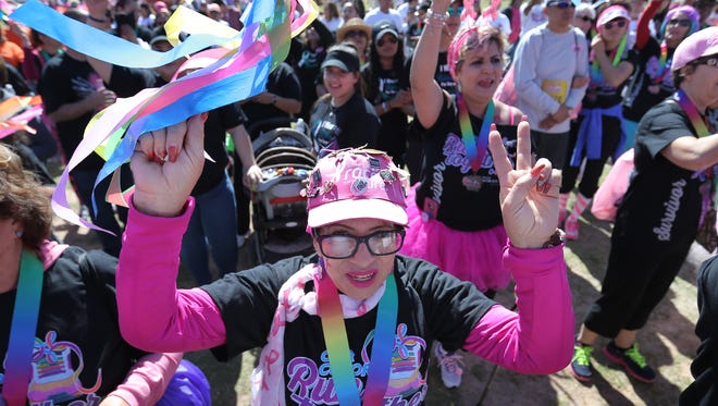 Breast cancer survivor Maria Lena dances with fellow cancer survivors following the Colors of Cancer: Our Colors Run Together event hosted by the Rio Grande Cancer Foundation at Cohen Stadium in April 2017.