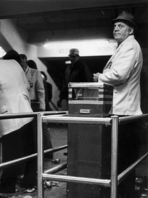 In this Dec. 3 1979 file photo, a ticket taker stares toward the doors of Riverfront Coliseum as a glove and a shoe, ripped from concert goers as they jammed into the facility, lay in mute testimony to the tragedy that occurred minutes earlier. Eleven people were crushed in a crowd gathered on the plaza of the facility waiting for the Who to perform inside.