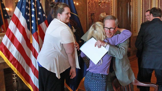 This March 25, 2014, file photo, Utah Rep. Gage Froerer, a Republican from Huntsville, who sponsored H.B.105 Plant Extract Amendments, hugs April Sintz, whose son Isaac has epilepsy, following the bill signing ceremony at the Utah State Capitol, in Salt Lake City. A Utah legislative committee met Wednesday, Oct. 19, 2016, to discuss whether marijuana should be legal for people with certain medical conditions. Froerer, says he plans to sponsor a bill that would help people with a wide array of medical conditions.