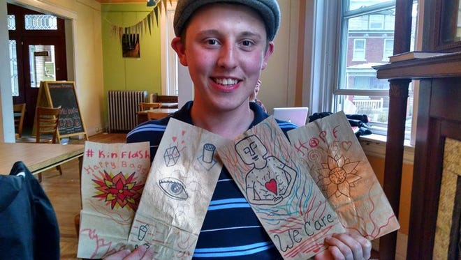 Colin Witte shows the decorated brown paper bags that will hold healthy snacks this Sunday.