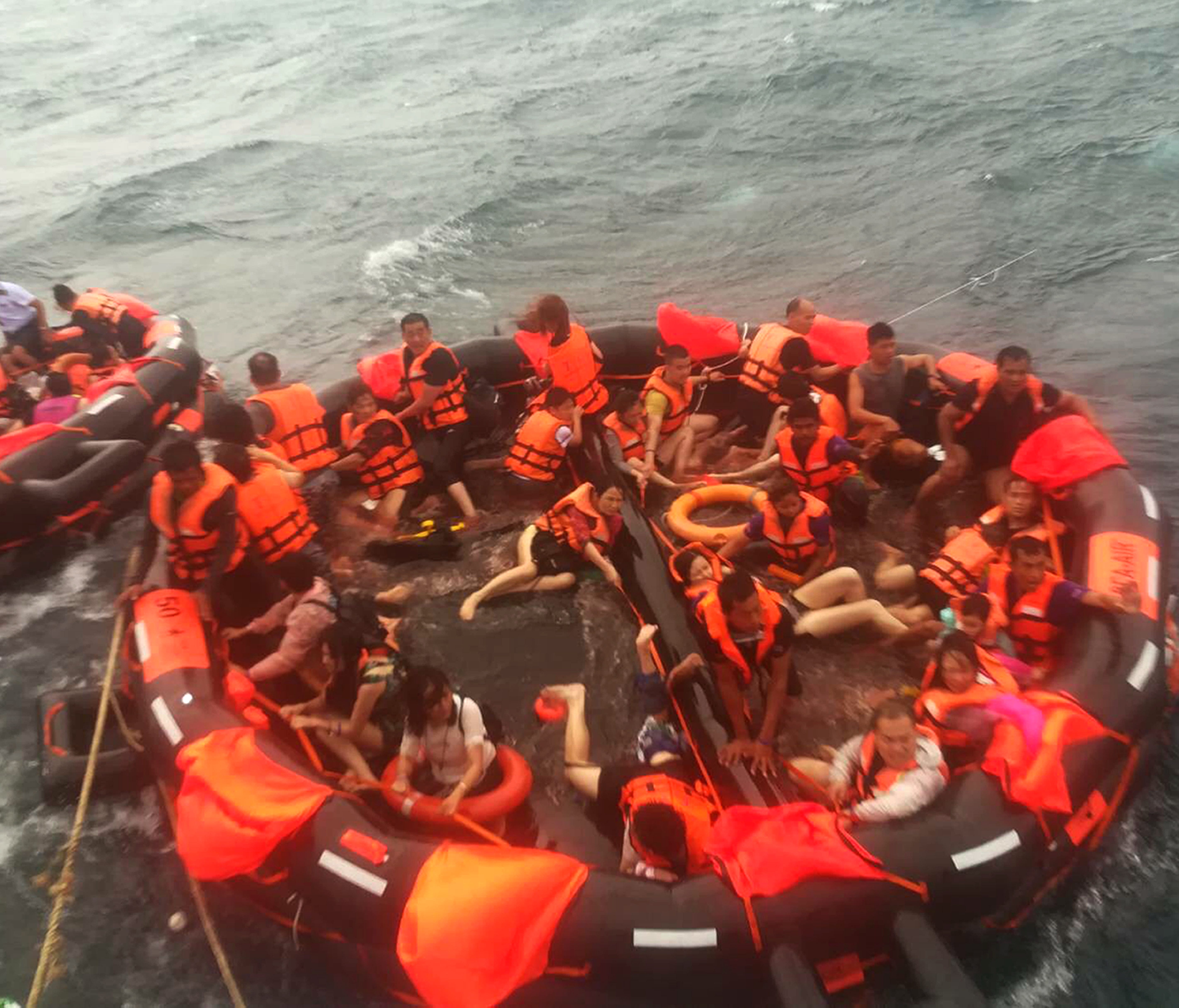 A handout photo made available by The Royal Thai Navy Third Area Command shows rescued tourists being brought aboard a fishing boat in the seas off the coast of Phuket Island, southern Thailand, July 5, 2018.