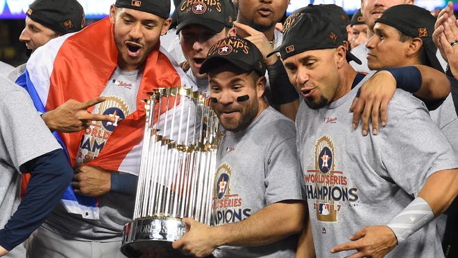 Nov 1, 2017; Los Angeles, CA, USA; Houston Astros second baseman Jose Altuve (center) celebrates with teammates with the Commissioner's Trophy after defeating the Los Angeles Dodgers in game seven of the 2017 World Series at Dodger Stadium. Mandatory Credit: Jayne Kamin-Oncea-USA TODAY Sports