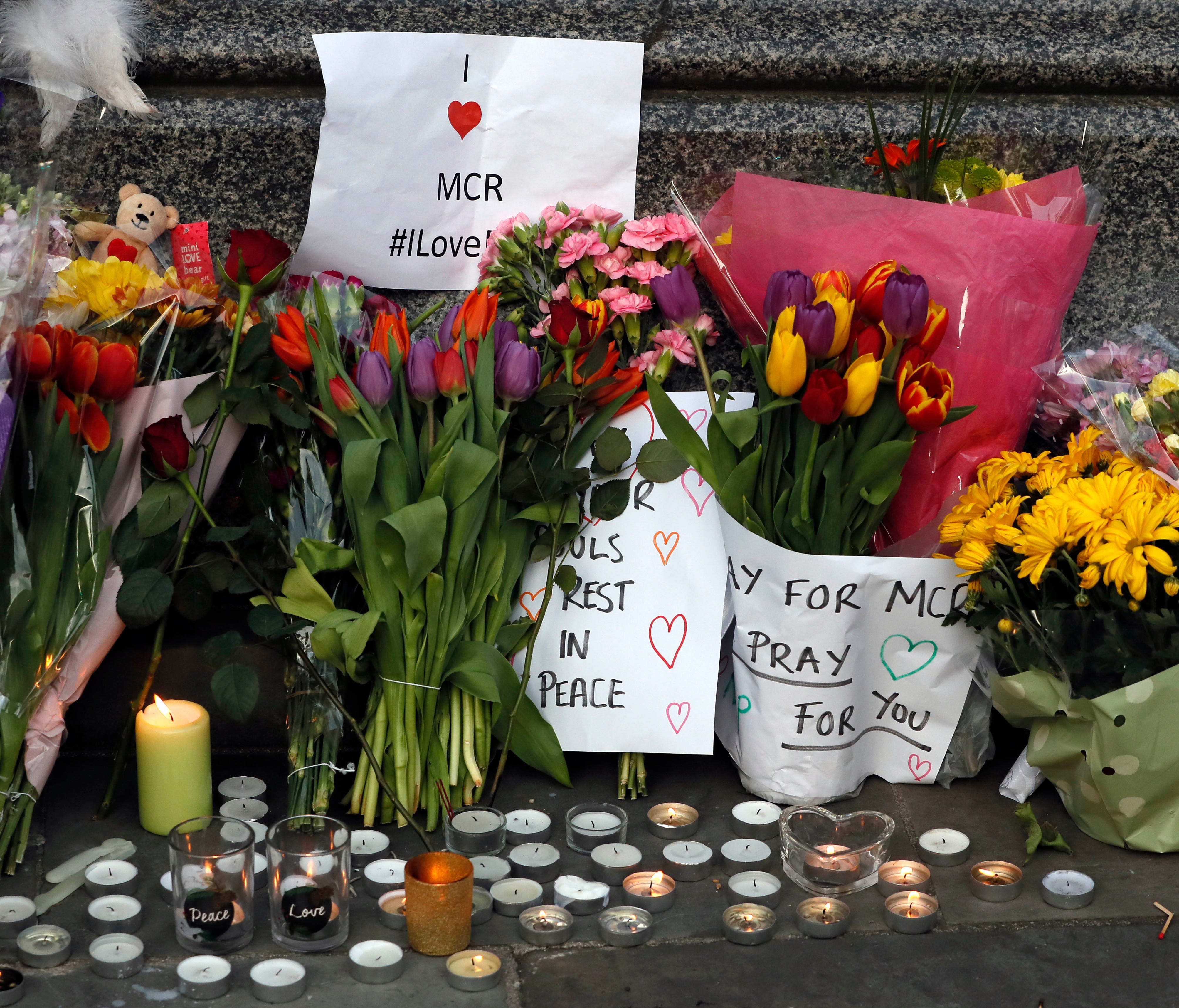 People lay flowers after a vigil in Albert Square, Manchester, England.