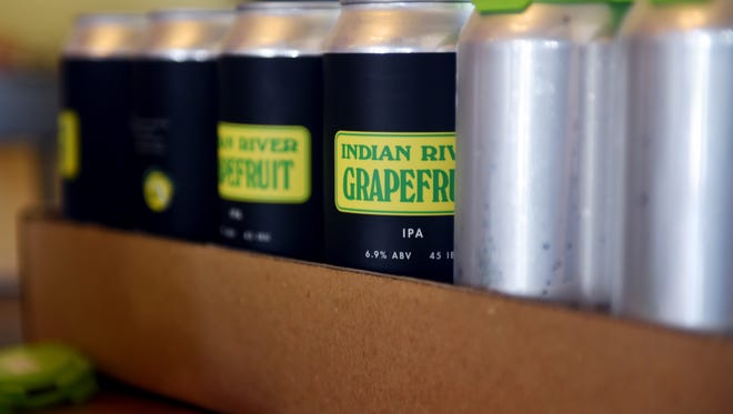 Labels for Orchid Island Brewery's Indian River Grapefruit, an American IPA, are placed on cans to be filled and sold. Orchid Island Brewery sources locally grown citrus for all of their beers.