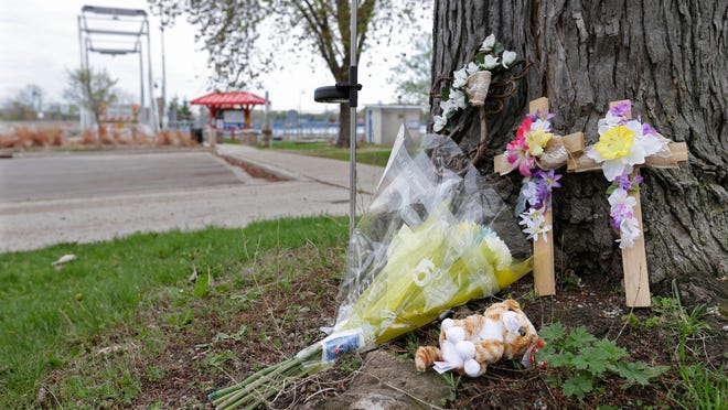 Flowers and other items have been placed as a memorial along Broad Street near the entrance to the Trestle Trail bridge in Menasha.