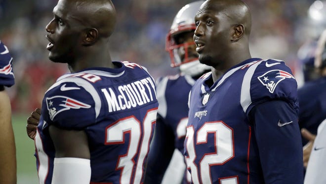 Patriots identical twins Jason McCourty (30) and Devin McCourty (32) watch from the sideline during a 2018 preseason game.
