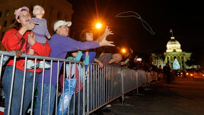 Families catch beads and candy during the Christmas Parade in downtown Montgomery, Ala. on Friday December 7, 2012. (Montgomery Advertiser, Mickey Welsh)