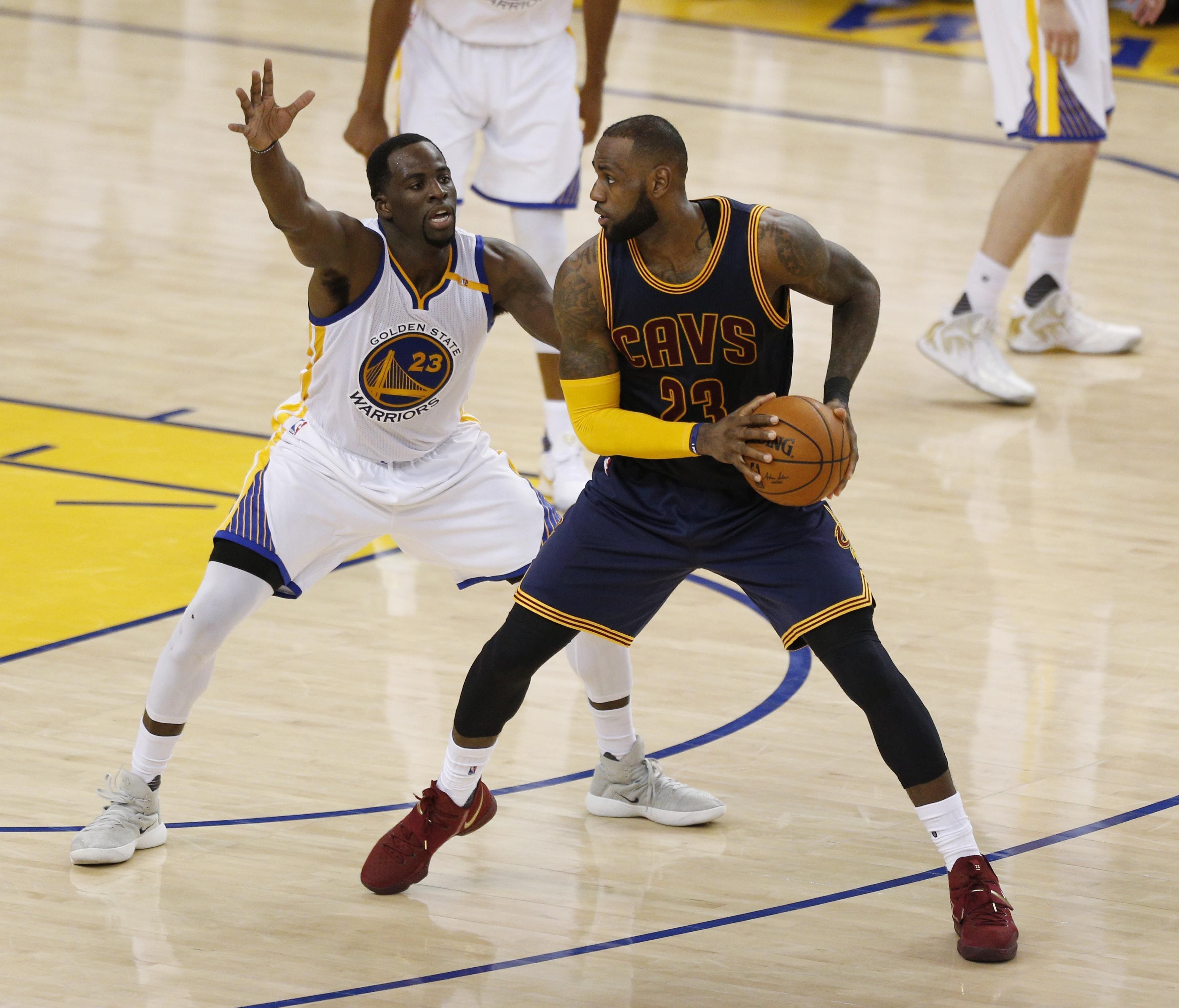 Cleveland Cavaliers forward LeBron James is defended by Golden State Warriors forward Draymond Green (23) in the fourth quarter of the NBA Finals at Oracle Arena.