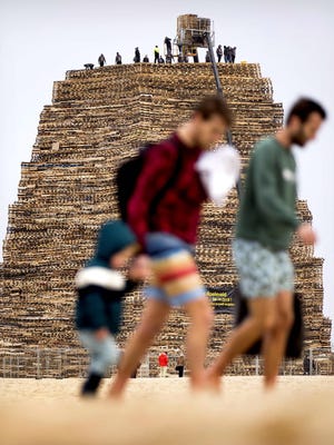 People pile up wooden pallets prior to the traditional bonfire of New Year eve on the beach of Scheveningen, on Dec. 30, 2018. Two dutch villages compete in building the biggest fire which will be lit on new years eve.