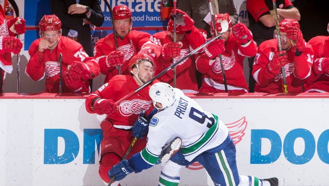 Tomas Jurco is checked into the boards by Vancouver's Brandon Prust in the second period.