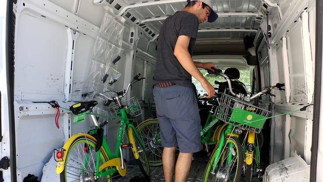 LimeBike's Reno Operations Manager Aaron Brukman secures a bike in the company van while moving it to a strategic location in Reno on June 28, 2018.