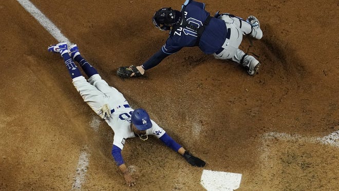 Mookie Betts of the Dodgers slides past the tag of Rays catcher Mike Zunino in the fifth inning of Game 1 of the World Series Tuesday night in Arlington, Texas.