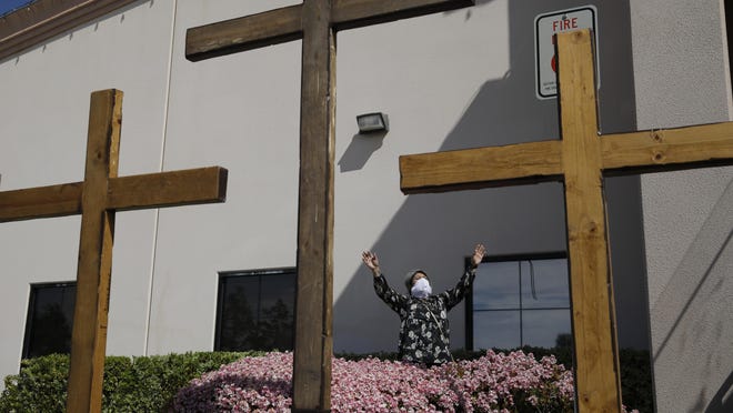 A woman prays while wearing a face mask at the International Church of Las Vegas. Two other churches seeking to overturn Nevada’s 50-person cap on religious gatherings amid the coronavirus pandemic were dealt a setback when a federal judge sided with the state.