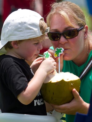Ben Moore and his mom Christine share a cold coconut Saturday. The annual festival celebrates Pine Island’s mangoes and other tropical fruits.