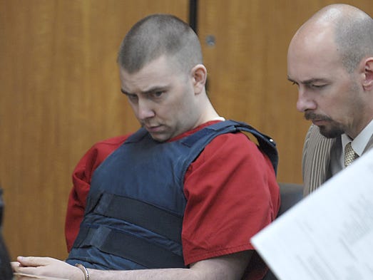 With head bowed, murderer James Biela looks at paperwork
