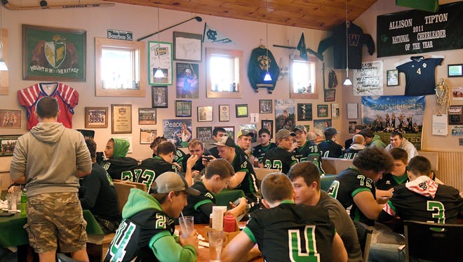 Players on the Mountain Heritage football team wait to head back to the stadium after eating dinner at Bubba's Good Eats in Burnsville on Friday, Nov. 10, 2017. The team eats at the restaurant before almost every game of the season. 