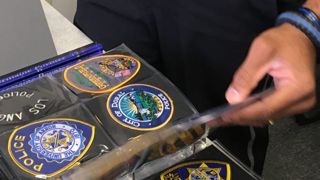 Lt. Poynter shows collection of police patches received during the FBI National Academy