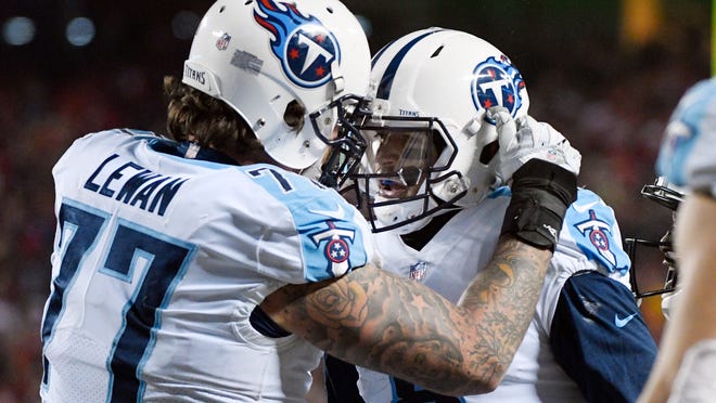 FILE -- In this Saturday, Jan. 6, 2018, file photo, Tennessee Titans offensive tackle Taylor Lewan (77) congratulates quarterback Marcus Mariota (8) after Mariota scored a touchdown against the Kansas City Chiefs during an NFL wild-card playoff football game in Kansas City, Mo. Lewan said Mariota has made big plays two weeks in a row to fire up the Titans, including a stiff-arm while running to a big first down to clinch Tennessee's playoff berth in the regular-season finale. (AP Photo/Ed Zurga, File)