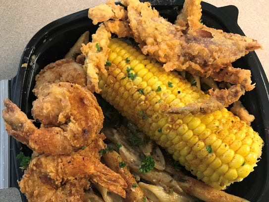 Fried soft-shell crab and shrimp top corn on the cob