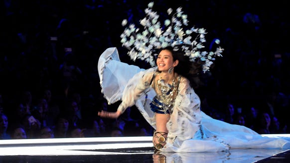 Ming Xi holds as smile as she falls on the runway.