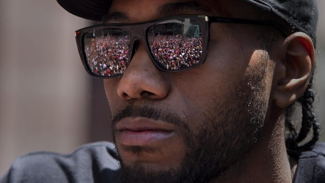 Cheering fans are reflected in the sunglasses of Toronto Raptors' Kawhi Leonard during the team's NBA basketball championship parade in Toronto, Monday, June 17, 2019.