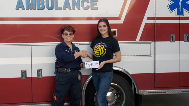 Mishicot Area Ambulance service director Theresa Becker accepts a monetary donation from Mishicot High School student Claire Hrubecky for the purchase of epi-pens. Hrubecky spearheaded a fundraising and awareness event as part of a “living to serve” plan implemented after attending a Washington Leadership Conference.