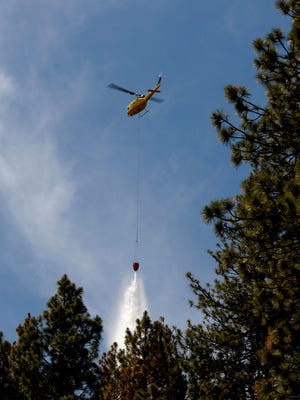A helicopter drops water on the Bryant Fire on June 22, 2014.