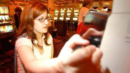 Amy Witherby, from Taylor Creek, Kentucky, pulls the handle for the slot machine while gambling at Grand Victoria Casino (now Rising Star) in Rising Sun, Indiana.