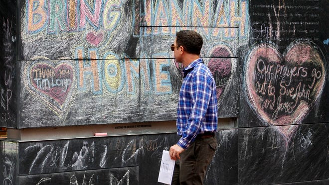 A pedestrian walks past chalk art reading "Bring Hannah Home" in Charlottesville on Thursday.