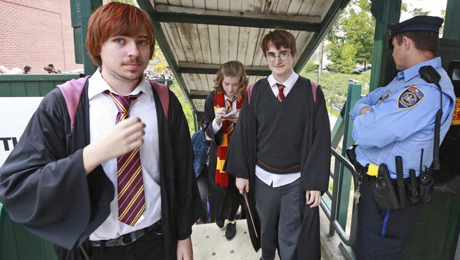 In this Oct. 18, 2014, photo, students from Chestnut Hill College in Philadelphia wear costumes to attend an annual Harry Potter festival. Dan Lemoine, second from right, dressed as the title character; Mollie Durkin, second from left, dressed as the character Hermione Granger; and John Spiewak Jr., left, dressed as the character Ron Weasley. In 2018, Warner Bros. notified organizers of Harry Potter fan festivals around the U.S. of new guidelines prohibiting any use of names, places or objects from the fantasy series, in an effort to crack down on unauthorized commercial activity at such events.
