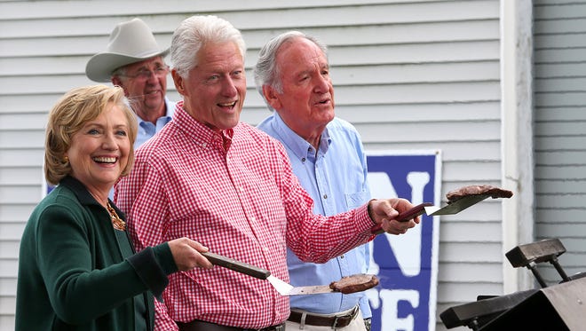 Democratic presidential candidate Hillary Clinton, along with her husband, former President Bill Clinton and Iowa Sen. Tom Harkin, flip steaks during the final Harkin Steak Fry in Indianola.