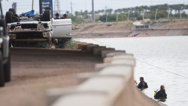 Divers look along the bottom of Tempe Town Lake as police respond to a car crash that killed five at Tempe Town Lake in Tempe on Sunday, Oct. 18, 2015.