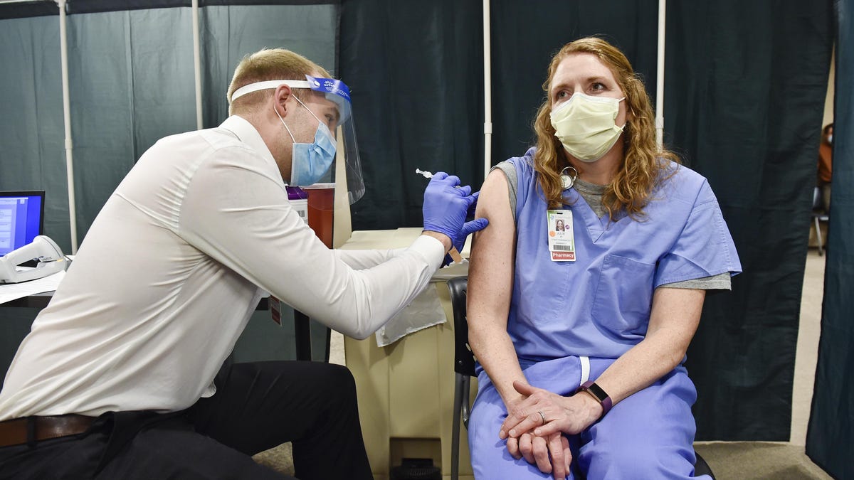 Julie Petre, an ICU pharmacist, receives a Pfizer COVID-19 vaccination at St. Peter's Health in Helena, Mont.