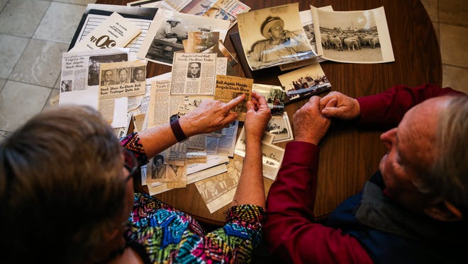 Becky and Karl Bookter look at photos and newspaper clippings of rodeos Wednesday, Jan. 31, 2018, at their San Angelo home. 