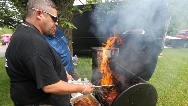 Marc Marcello works on his competition ribs, chicken, pork and brisket at the Roc City Rib Fest.  Marcello is with Smoking Eagle BBQ & Brew in LeRoy and 58 Main in Brockport. 