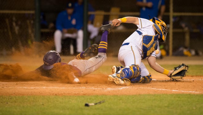 Fort Pierce Central's Ty'Reik Martin slides past John Carroll Catholic catcher Andrew Bourque in the seventh inning to score during the high school baseball game Wednesday at Bob Gladwin Complex in Fort Pierce. Central's John Martin broke his bat, seen at bottom, hitting Martin in to score.