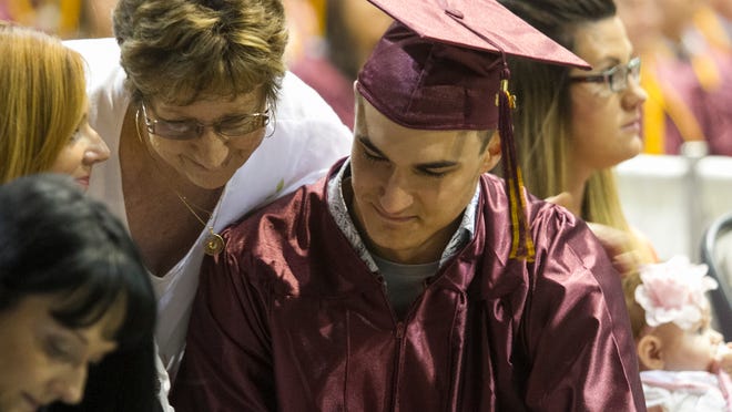 Dorit Perella, center, hugs her grandson Dakota Perella after he received his cousin Devin Reynaert's diploma at Riverdale High School's graduation on Saturday, May 30, 2015, at the Lee Civic Center in Fort Myers. Reynaert was killed in a car crash on May 1. At left is his mother Devin's mother Desiree Perella.