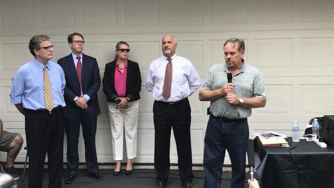 Bruce Tenniswood, right, and around 135 other residents in the Alden Village neighborhood of Livonia, Michigan say Ford Motor Co. has tainted groundwater that is seeping into their neighborhood, damaging property values and causing health risk. He photographed here outside his home Aug. 9, 2017, with a team of lawyers representing homeowners in the neighborhood.