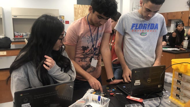Spanish River High students Nishah Jaferi, from left, Aditya Kumar and Abdel Kareem Hilo work on coding an Arduino that is responsible for the maintenance of the functions of a pulse oximeter, a device used to track and monitor the blood pressure rate and pressure. The school's InvenTeam is developing a prototype to monitor patients in the intensive care unit who may be predisposed to sepsis.