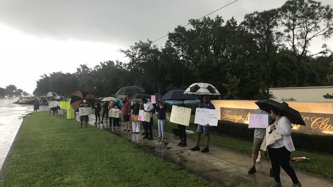 Protesters gather outside Trump National Golf Club in Jupiter on Friday evening.
