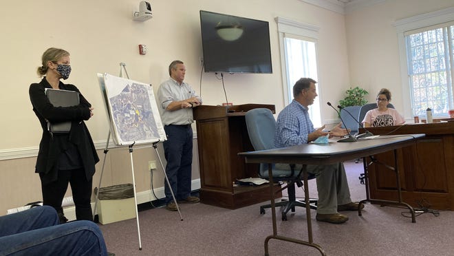 Hank Ouimet, seated, of Renewable Energy Development Partners and co-founder and managing director Tom Melehan along with consultant Sarah Stearns review the purchase of agricultural land with the Select Board.