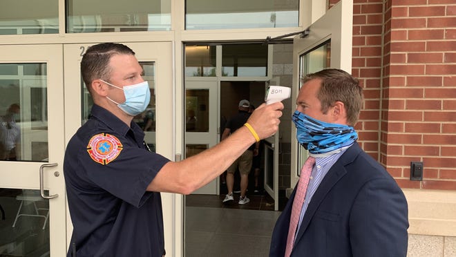 Patrick Daley of the Marshfield Fire Department takes the temperature of State Rep. Patrick Kearney before entering Marshfield Town Meeting on Monday, June 22.