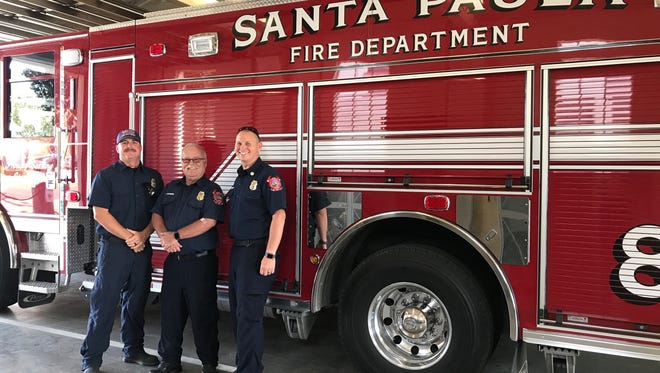 Longtime Santa Paula firefighters stand next to one of four fire engines slated for replacement by the county when it takes control of the city's fire services Sunday. From left are firefighter Matthew Lindsey, Engineer John Harber and Capt. Dustin Lazenby.