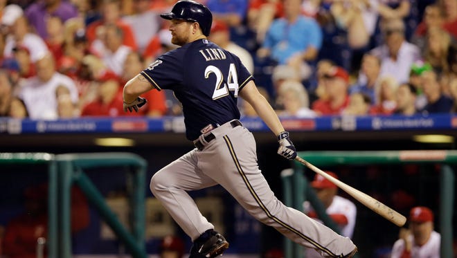 Milwaukee Brewers first baseman Adam Lind follows through after hitting the go-ahead RBI-single off Philadelphia Phillies relief pitcher Luis Garcia during the 11th inning on Thursday, July 2, 2015, in Philadelphia.