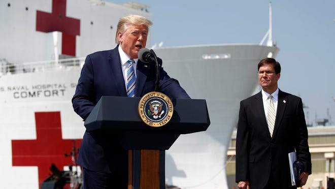 President Donald Trump speaks in front of the U.S. Navy hospital ship USNS Comfort at Naval Station Norfolk in Norfolk, Va., Saturday, March 28, 2020. The ship is departing for New York to assist hospitals responding to the coronavirus outbreak. Defense Secretary Mark Esper is at right.