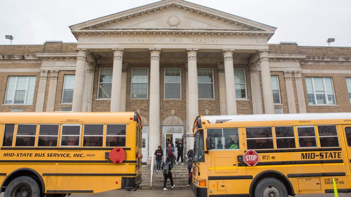 Students board buses in front of NFA