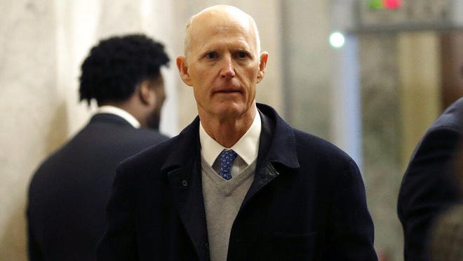 Sen. Rick Scott, R-Fla., arrives at the Capitol Hill in Washington, Tuesday, Jan. 21, 2020. President Donald Trump's impeachment trial quickly burst into a partisan fight Tuesday as proceedings began unfolding at the Capitol. Democrats objected strongly to rules proposed by the Republican leader for compressed arguments and a speedy trial.