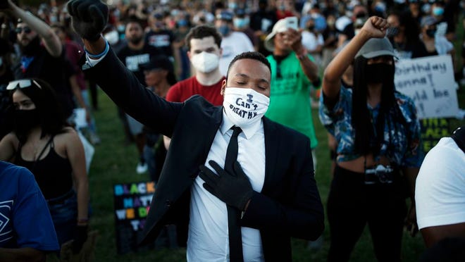 People raise their fists during a rally, Friday, June 5, 2020, in Las Vegas, against police brutality sparked by the death of George Floyd, a black man who died after being restrained by Minneapolis police officers on May 25.
