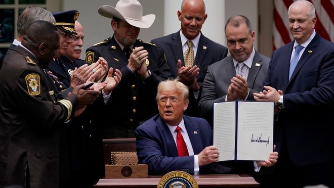 Law enforcement officials applaud after President Donald Trump signed an executive order on police reform, in the Rose Garden of the White House, Tuesday, June 16, 2020, in Washington.